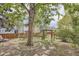 Spacious backyard with a large tree, wooden fence, and garden gate at 7198 Eaton Ct, Arvada, CO 80003