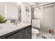Bathroom features shower with glass doors, gray vanity, and stylish shelving at 7198 Eaton Ct, Arvada, CO 80003