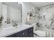 Modern bathroom featuring navy blue vanity, marble tiled shower, and white fixtures at 7198 Eaton Ct, Arvada, CO 80003