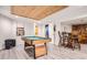 Finished game room with pool table, tongue and groove accent ceiling, and hardwood bar at 7198 Eaton Ct, Arvada, CO 80003