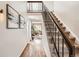 Hallway with hardwood floors, staircase, and view into the living room at 7198 Eaton Ct, Arvada, CO 80003