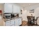 Cozy kitchenette features white cabinets, marble countertop, appliances, and table with chairs at 7198 Eaton Ct, Arvada, CO 80003