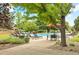 A large shady tree casts shadows on the pool deck offering lounge chairs and tables for residents to enjoy at 6410 Silver Mesa Dr # B, Highlands Ranch, CO 80130