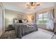 Comfortable main bedroom featuring a ceiling fan, large window with view, and a decorative bed with throw blanket at 6410 Silver Mesa Dr # B, Highlands Ranch, CO 80130