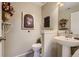 Cozy powder room with pedestal sink, decorated with an antique vanity, and a floral wall decoration at 6410 Silver Mesa Dr # B, Highlands Ranch, CO 80130