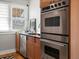 Close-up of kitchen details with stainless steel oven and dishwasher, and natural light from the window at 361 S Logan St, Denver, CO 80209