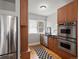 Galley kitchen featuring stainless steel appliances, wood cabinets, and a window with natural light at 361 S Logan St, Denver, CO 80209