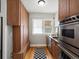Cozy kitchen with wood cabinets, stainless steel appliances, and built-in storage under a bright window at 361 S Logan St, Denver, CO 80209
