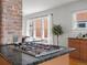 Granite countertop gas cooktop in a kitchen with exposed brick, a large window, and lots of natural light at 361 S Logan St, Denver, CO 80209
