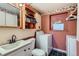 Compact laundry area featuring a sink, toilet, washer and dryer, and storage space at 2155 S Lewiston St, Aurora, CO 80013