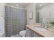 Neutral bathroom featuring a patterned shower curtain, a modern vanity, and a decorative plant; well-lit and functional at 1325 Jackson St, Denver, CO 80206