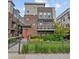 Stylish modern townhouse with a brick facade, balcony, a red front door and a well-maintained fenced yard at 1325 Jackson St, Denver, CO 80206