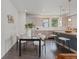 Contemporary dining area with a glass table set adjacent to a kitchen with bar seating at 1325 Jackson St, Denver, CO 80206