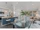 Open-concept kitchen and dining area with modern fixtures, stainless appliances, and a glass dining table at 1325 Jackson St, Denver, CO 80206