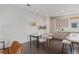 Dining area with seating and a glass table, complemented by a modern kitchen and decor at 1325 Jackson St, Denver, CO 80206