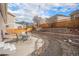 Landscaped backyard featuring a stone retaining wall, patio and table setting, and privacy fence at 1811 Hogan Ct, Castle Rock, CO 80109