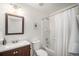 Clean bathroom features a bath and shower, a dark wood vanity, and a large, framed mirror at 1811 Hogan Ct, Castle Rock, CO 80109