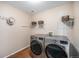 Efficient laundry room with wood floors, wire shelving, and modern washer and dryer units at 1811 Hogan Ct, Castle Rock, CO 80109