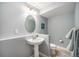Light-blue half bathroom features a pedestal sink, decorative mirror, and standard toilet at 1811 Hogan Ct, Castle Rock, CO 80109