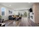 The living room has hardwood floors, a stone fireplace, a black leather couch, and sliding glass doors to the back patio at 22669 E Tufts Pl, Aurora, CO 80015