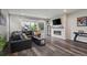 The living room has hardwood floors, a stone fireplace, a black leather couch, and sliding glass doors to the back patio at 22669 E Tufts Pl, Aurora, CO 80015