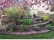 Landscaped backyard featuring vibrant flowers, stone garden decor, and lush greenery at 829 Colorado Blvd, Idaho Springs, CO 80452