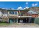 Two-story home featuring a covered deck, green siding, garage, and well-maintained surroundings at 829 Colorado Blvd, Idaho Springs, CO 80452