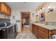 Convenient laundry area with washer, dryer, utility sink, and cabinetry, adjacent to additional living space at 829 Colorado Blvd, Idaho Springs, CO 80452