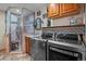 Well-equipped laundry room with modern washer and dryer, utility sink, and shower at 829 Colorado Blvd, Idaho Springs, CO 80452