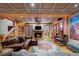Finished basement with a cozy fireplace, comfortable seating, and an intricately patterned ceiling at 829 Colorado Blvd, Idaho Springs, CO 80452