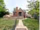 Charming brick home featuring a classic Tudor archway and a well-manicured front yard at 2710 Stuart St, Denver, CO 80212