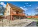 Exterior of home with a brick foundation and a large patio with walkout access at 5420 E 61St Way, Commerce City, CO 80022