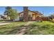 Charming home featuring a brick chimney, well-manicured lawn, and a welcoming front walkway at 5420 E 61St Way, Commerce City, CO 80022