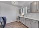 Bright laundry room with gray cabinets, countertop, and a dog crate at 7706 S Duquesne Way, Aurora, CO 80016