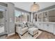 Bright sitting room with two armchairs, ottoman, and built-in cabinets at 7706 S Duquesne Way, Aurora, CO 80016