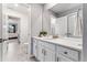 Bright bathroom boasts a white vanity with quartz countertops and elegant gray tile flooring at 19894 W 94Th Ln, Arvada, CO 80007
