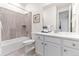 Well-lit bathroom with tub and shower combination, white cabinets, quartz countertop and tile flooring at 19894 W 94Th Ln, Arvada, CO 80007