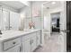 Bright bathroom features a double sink vanity with white quartz countertops and gray floors at 19894 W 94Th Ln, Arvada, CO 80007