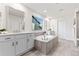 Bright bathroom with a soaking tub, double vanities, and modern finishes at 19894 W 94Th Ln, Arvada, CO 80007