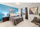Stylish bedroom featuring a blue accent wall, plush bedding, and large windows with neighborhood views at 19894 W 94Th Ln, Arvada, CO 80007