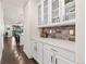 Butler's pantry with white cabinets, display shelves, quartz countertops and decorative backsplash at 19894 W 94Th Ln, Arvada, CO 80007