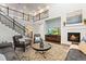 Living room with a fireplace, hardwood floors, comfortable seating, and a view of the staircase at 19894 W 94Th Ln, Arvada, CO 80007