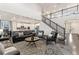 Open-concept living room with hardwood floors, stairs to the second level, and a view into the kitchen at 19894 W 94Th Ln, Arvada, CO 80007