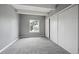 Bedroom featuring gray walls, gray carpet, a window, and a closet with sliding doors at 9995 E Harvard Ave # 166, Denver, CO 80231