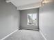 This bedroom has gray walls, gray carpet, a window, and white ceiling beams at 9995 E Harvard Ave # 166, Denver, CO 80231