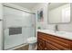 Bathroom featuring wood-toned vanity, white countertop, and glass-enclosed shower at 3611 W 79Th Ave # B4, Westminster, CO 80030