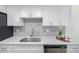 Updated kitchen with stainless steel sink, white cabinets, quartz countertops and tile backsplash at 3611 W 79Th Ave # B4, Westminster, CO 80030