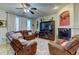 Cozy living room with leather furniture, hard wood floors, ceiling fan, fireplace, and bright windows at 1995 E 166Th Ave, Thornton, CO 80602