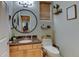 Stylish powder room features a round mirror, wood cabinets, neutral paint and plenty of decorative touches at 1995 E 166Th Ave, Thornton, CO 80602