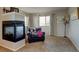 Inviting sitting area featuring fireplace, chair, natural light, and neutral carpet at 1995 E 166Th Ave, Thornton, CO 80602